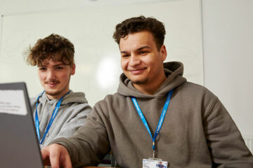 Two students sat at a laptop
