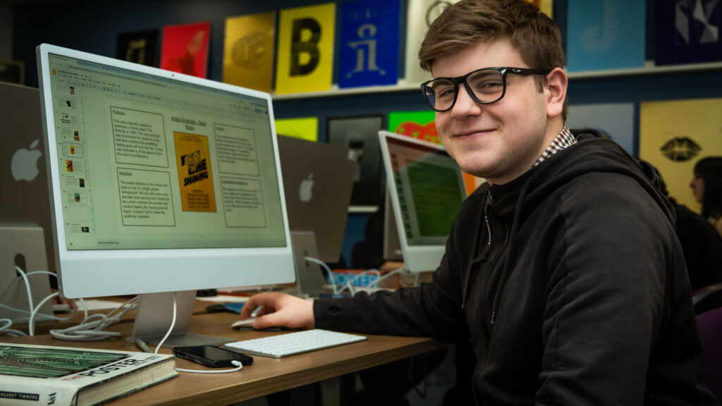 Graphics student sat at an Apple Mac