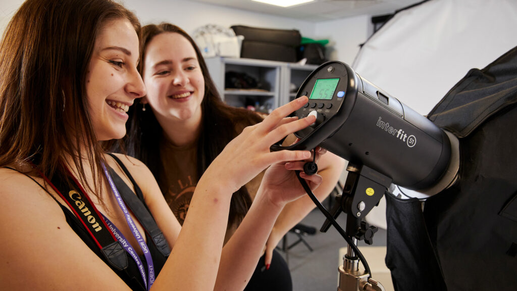Two students looking at photography equipment