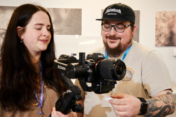 A student and a lecturer looking at a camera