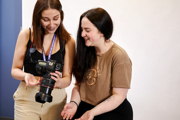 Two students looking at photos on a camera