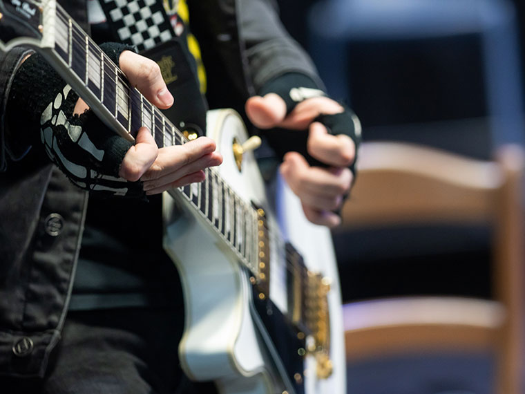 Close up of a student playing the guitar