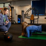 A student being timed doing a plank in the gym