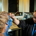 A media make-up student creating a theatrical look on a client