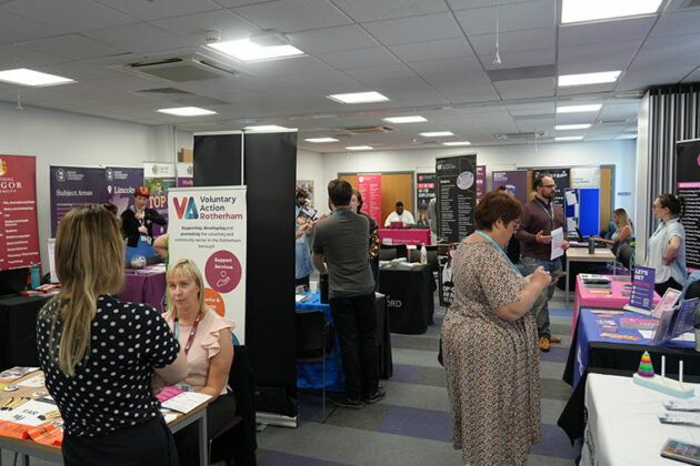 People chatting at the HE Fair