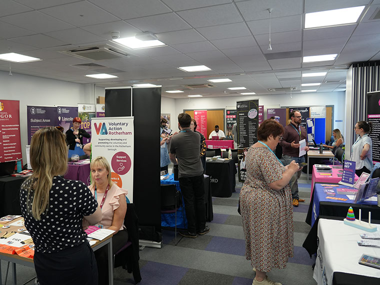 People chatting at the HE Fair