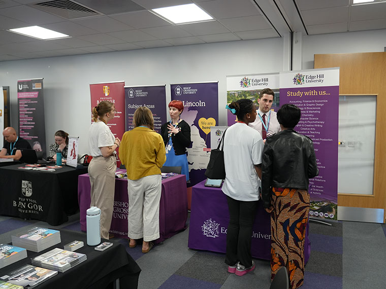 People chatting at the HE Fair