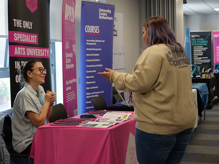 Two people chatting at the HE Fair