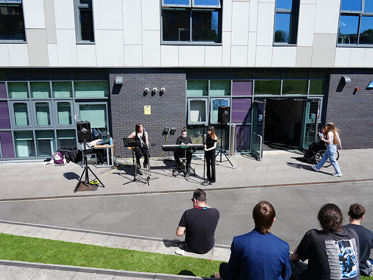 A student band playing in the outdoor amphitheatre in University Centre Rotherham during the HE Fair