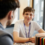 Student sat at a desk smiling