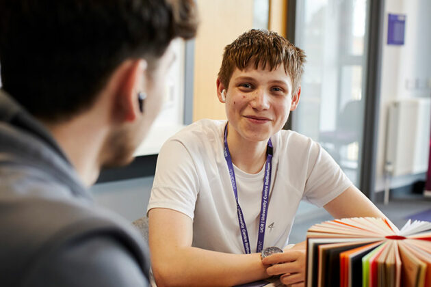 Student sat at a desk smiling