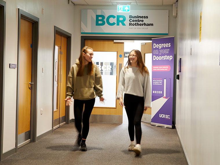 Two people walking down the corridor near the BCR