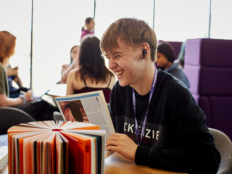 A student sat at a table reading a book