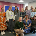 A group of staff members standing with Beth Hall at her leaving event