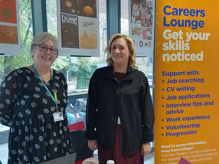 Careers staff stood next to a Careers Lounge banner
