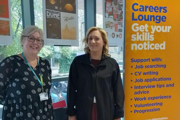 Careers staff stood next to a Careers Lounge banner