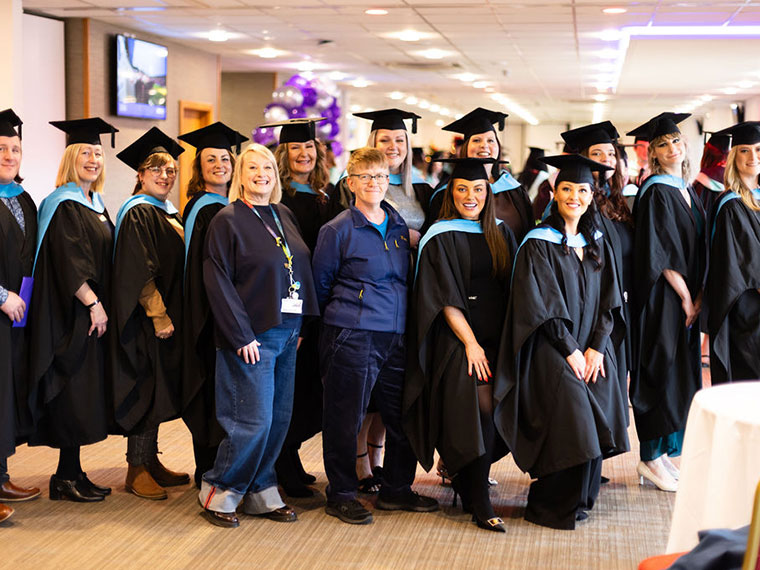 A group of graduations smiling at the camera