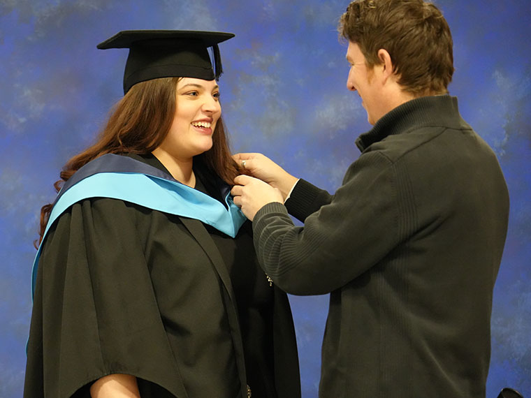 A graduand being gowned before the ceremony