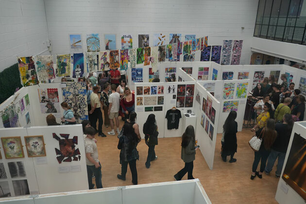 Rotherham College's creative showcase 2025 - People looking at student's artwork hung on the wall