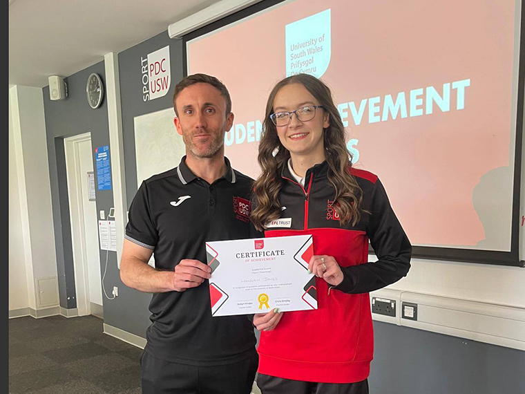 Hannah stood with a male holding a certificate between them